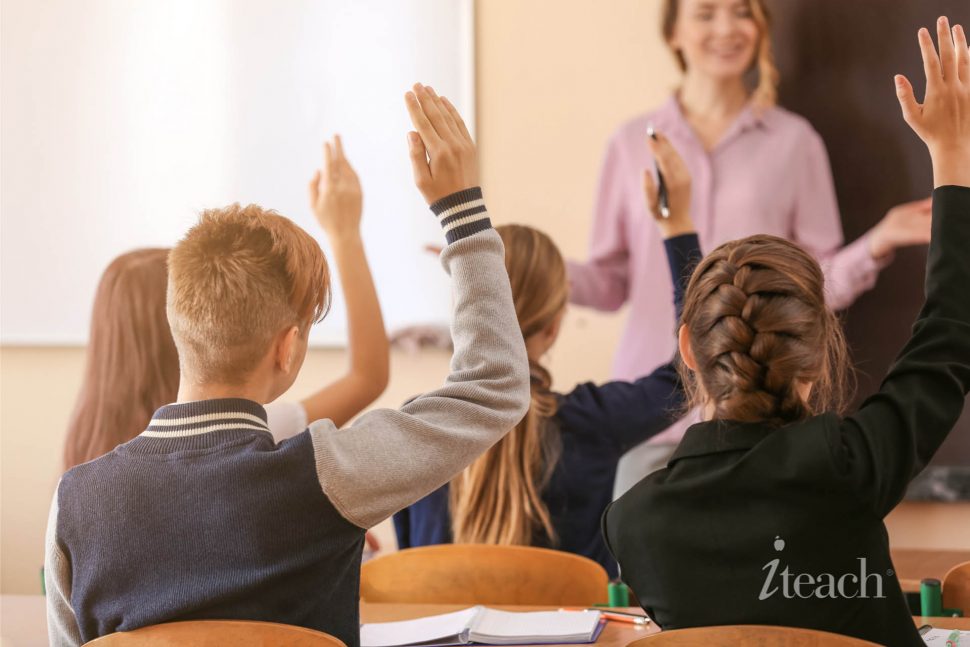 Students in a Classroom with their hands raised
